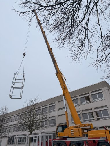 Telescopic crane in front of the AMG