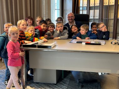 Kinder am Schreibtisch des Bürgermeisters