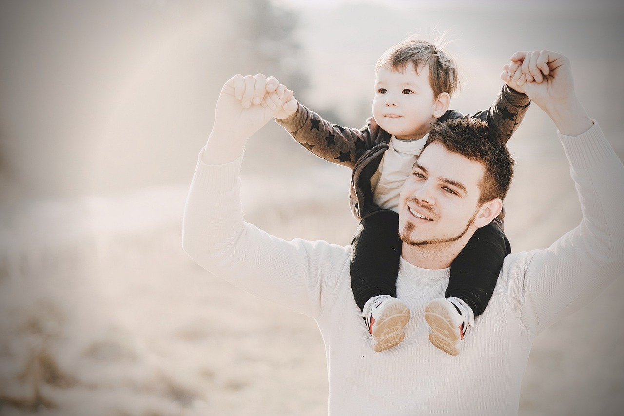 Young man with child on his shoulders