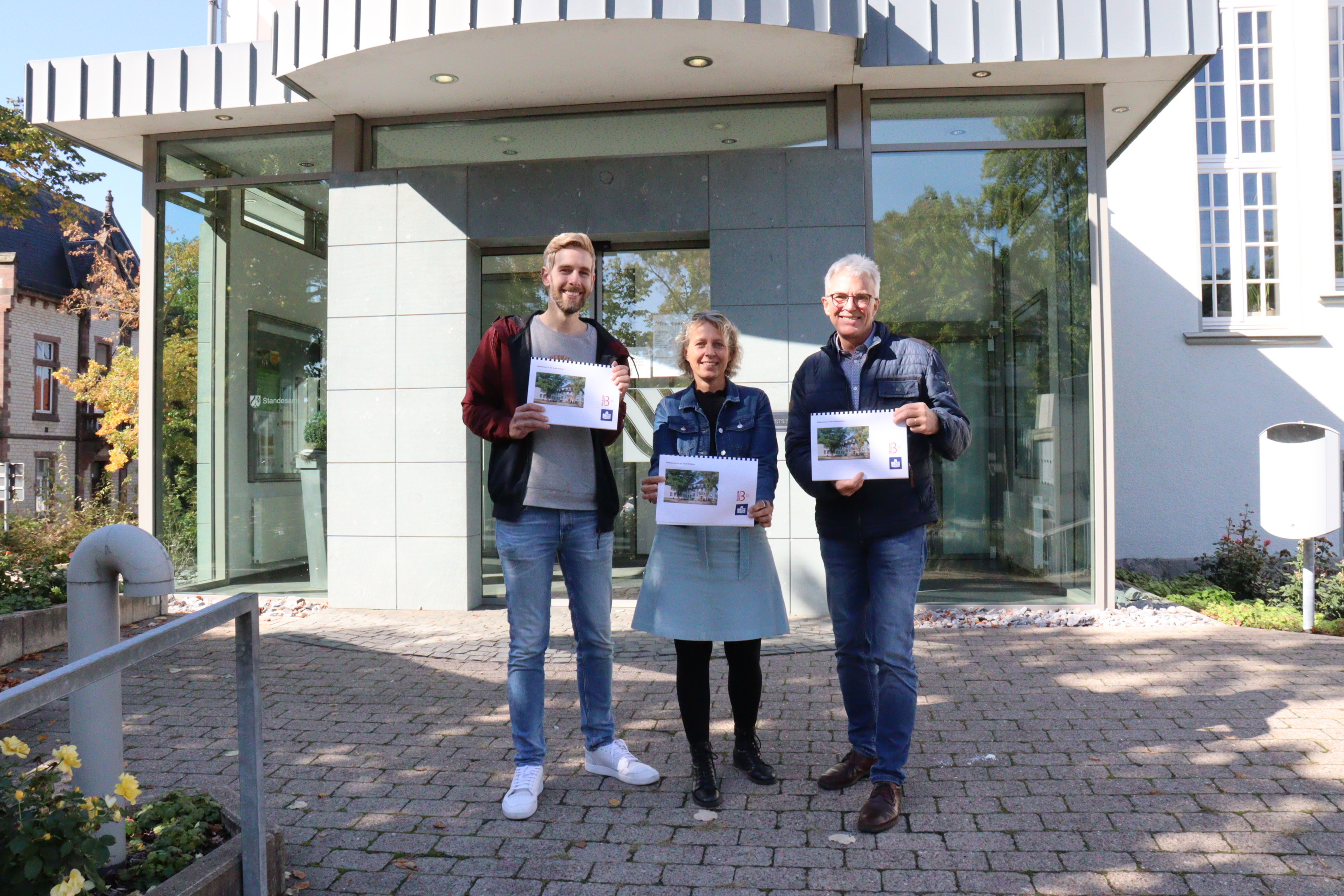 Uitreiking van de vertaalde brochure: van links Max Ruhmann, Sandra Berges (beiden persbureau van de stad Beckum) en het hoofd van de sociale dienst Martin May-Neitemann.