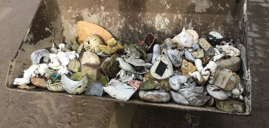 Müllcontainer mit beschädigten Grabbeigaben