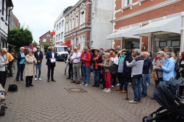 Personengruppe verfolgt die Verlegung eines Stolpersteins