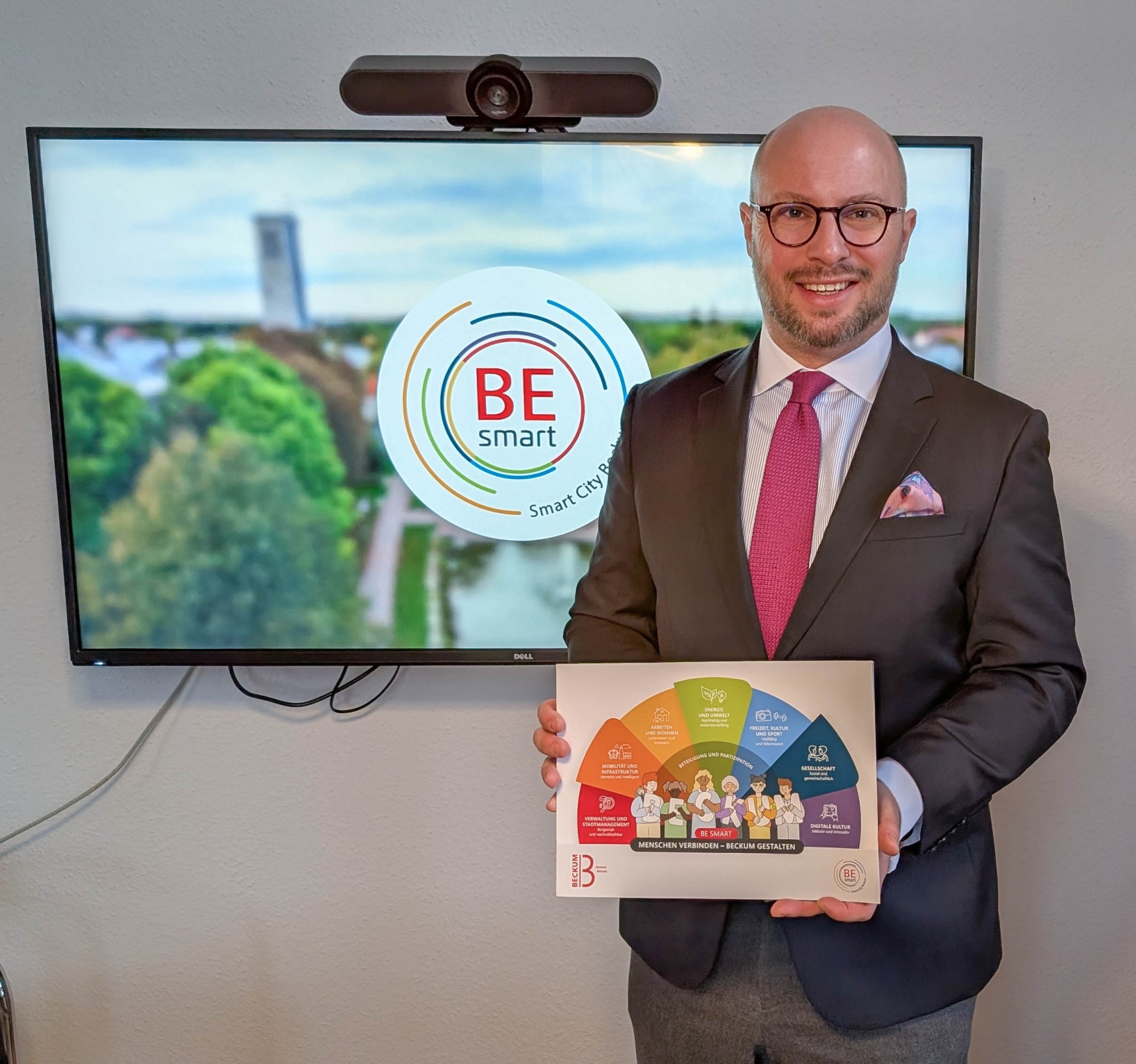 Bürgermeister Michael Gerdhenrich mit der Broschüre vor dem Video